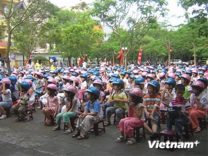 Tuyên truyền về đội mũ bảo hiểm cho học sinh tiểu học.