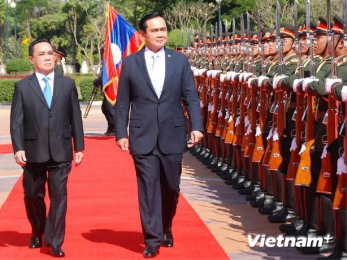 Thủ tướng Thái Lan Prayuth Chan-ocha và Thủ tướng Lào Thongsing Thammavong duyệt đội danh dự. (Ảnh: Hoàng Chương/Vietnam+)