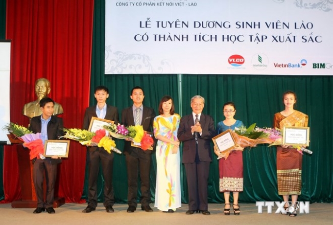 Khen thưởng các sinh viên Lào vượt qua hoàn cảnh khó khăn, vươn lên trong học tập. (Ảnh: Phạm Kiên/TTXVN)