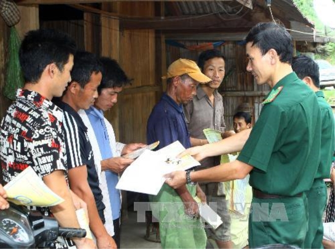 Cán bộ Đồn biên phòng tuyên truyền chính sách, pháp luật của Đảng , Nhà nước cho đồng bào dân tộc Mông ở bản Cà Là Pá. Ảnh: Trọng Đức - TTXVN.