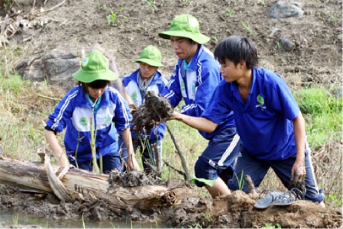 Sinh viên tình nguyện Trường Đại học Nông Lâm TP. Hồ Chí Minh giúp nhân dân xã Đak Smar (huyện Kbang, tỉnh Gia Lai) đắp bờ ruộng lúa. (Ảnh: Lê Ngọc)