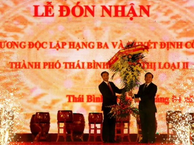 Phó Thủ tướng Hoàng Trung Hải tặng hoa chúc mừng Đảng bộ và nhân dân Thành phố Thái Bình. (Ảnh: Thu Hoài/TTXVN)