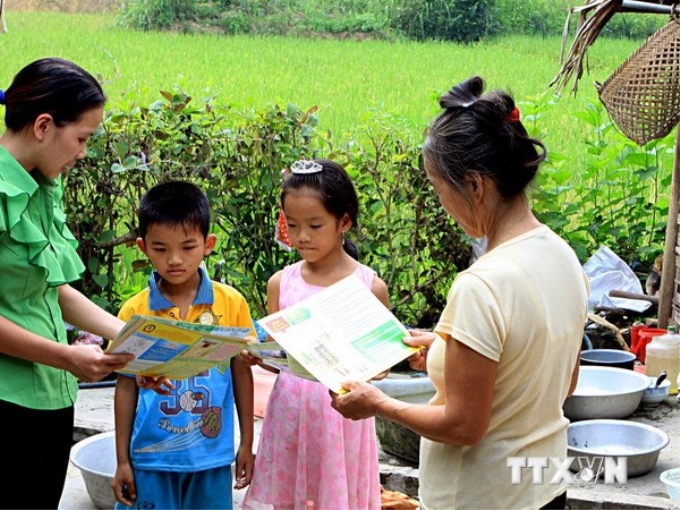 Nhân viên y tế tuyên truyền cho người dân về biện pháp phòng chống dịch bệnh như sốt xuất huyết. (Ảnh: TTXVN)