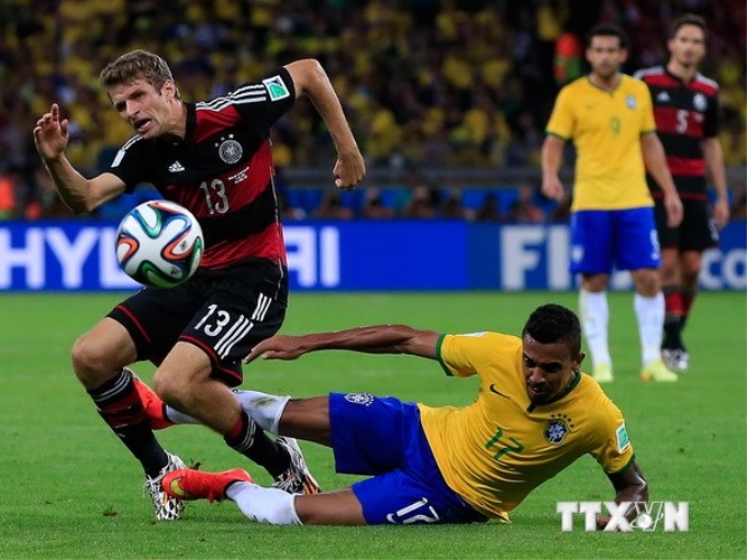 Trung vệ Luiz Gustavo (phải) đội tuyển Brazil truy cản quyết liệt tiền đạo Thomas Mueller (trái). (Ảnh: AFP/TTXVN)