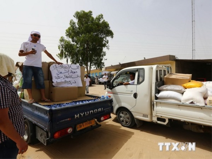 Xe chở hàng cứu trợ phân phát cho người dân tại Qasr bin Ghashir, gần sân bay quốc quốc tế ở Tripoli, nơi đang diễn ra giao tranh ác liệt giữa các nhóm vũ trang. (Nguồn: AFP/TTXVN)