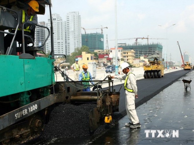 Cán bộ công nhân công ty Cienco 4 dải thảm bêtông asphalt đoạn Trung Hòa - Thanh Xuân. (Ảnh: Huy Hùng/TTXVN)