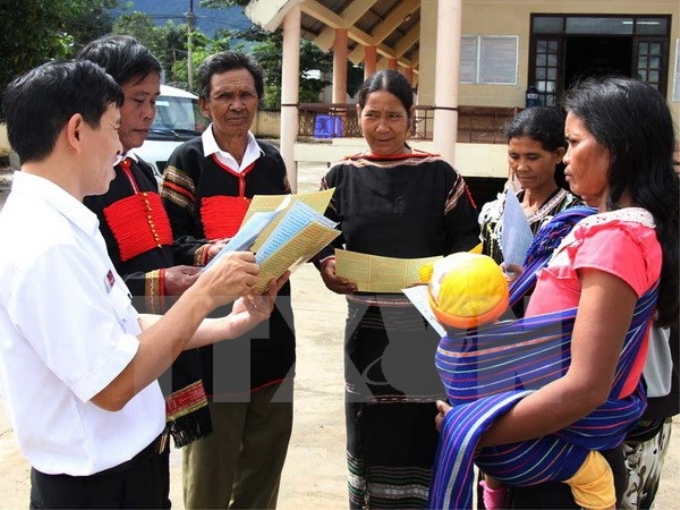 Cán bộ Sở Tư pháp hướng dẫn người dân xã Cư Pui, huyện Krông Bông, Đắk Lắk tìm hiểu các văn bản pháp lý. (Ảnh: Phạm Cường/TTXVN)