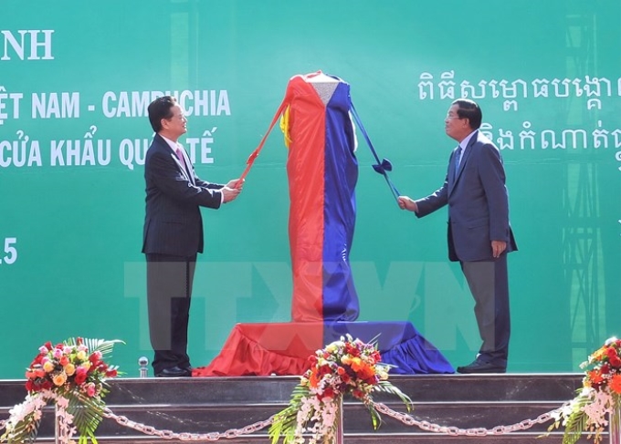 Thủ tướng Nguyễn Tấn Dũng và Thủ tướng Campuchia Hun Sen thực hiện nghi thức mở băng khánh thành Cột mốc 30 và đường nối hai trạm kiểm soát. (Ảnh: TTXVN)