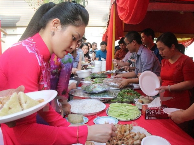 Bà con thưởng thức món ăn truyền thống dân tộc. (Ảnh: Kim Dung-Chí Giáp/Vietnam+)