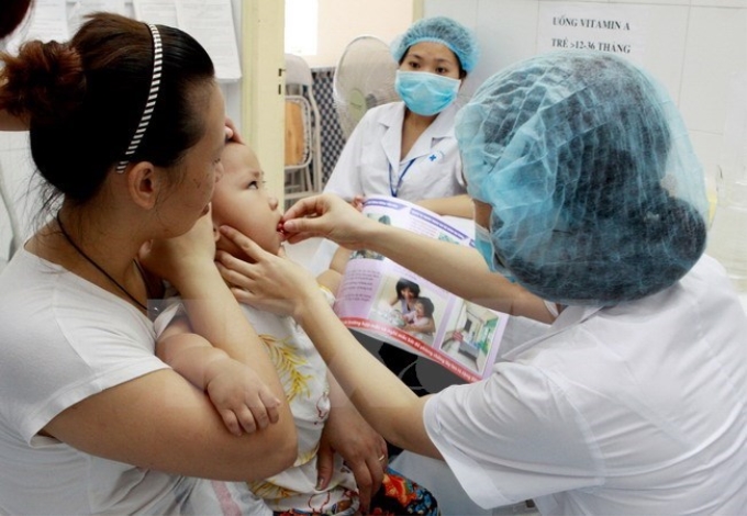 Cho trẻ uống Vitamin A tại quận Đống Đa, Hà Nội. (Ảnh: TTXVN)