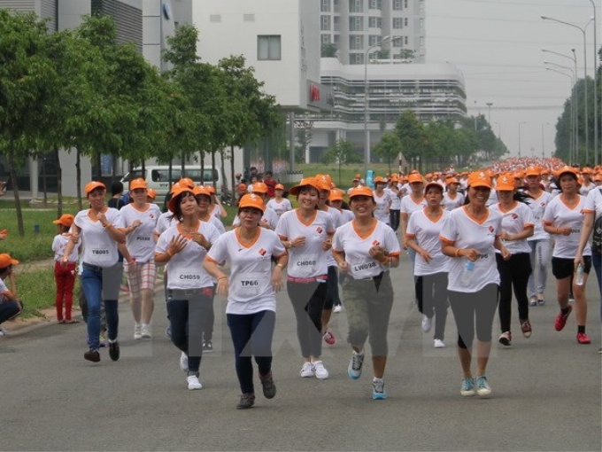 Công nhân dệt may chạy bộ vì "Sức khỏe và an toàn lao động” tại thành phố mới Bình Dương. (Ảnh: TTXVN)