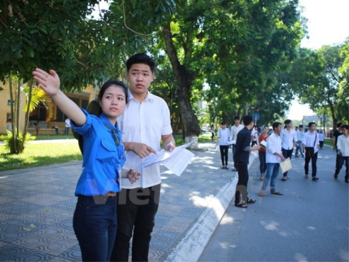 Sinh viên tình nguyện hướng dẫn thí sinh đên làm thủ tục dự thi sáng nay, 30/6. (Ảnh: Vietnam+)