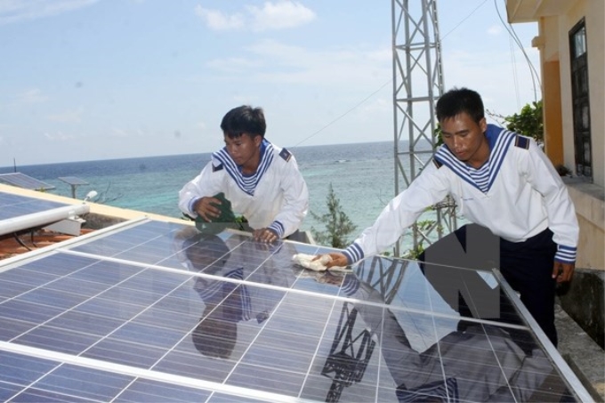 Chiến sỹ đảo Sinh Tồn Đông bảo dưỡng hệ thống pin Mặt Trời. (Ảnh: TTXVN)