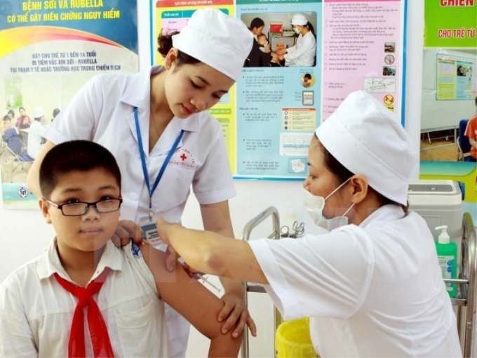 Cán bộ y tế tiêm phòng sởi-rubella cho học sinh. (Ảnh: TTXVN)