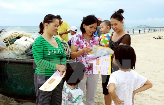 Cán bộ dân số cấp phát bao cao su, thuốc tránh thai cho những người làm việc trên biển tại quận Sơn Trà, Đà Nẵng. (Ảnh: TTXVN)