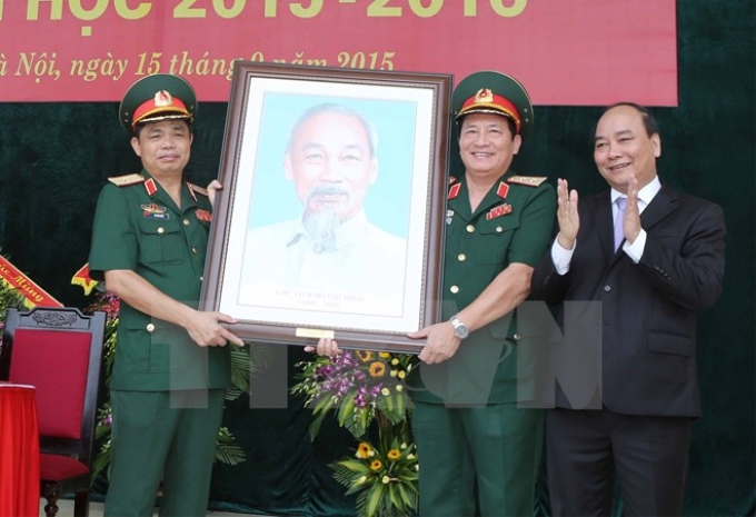 Phó Thủ tướng Nguyễn Xuân Phúc tặng quà lưu niệm cho Học viện Hậu cần. (Ảnh: Phương Hoa/TTXVN)