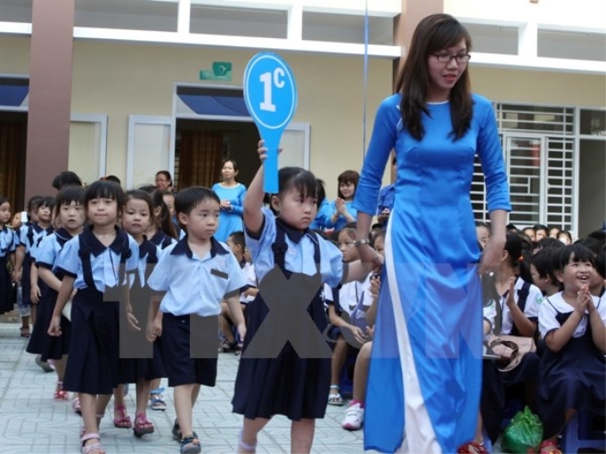 Cô và trò Trường Tiểu học Bạch Đằng, Thành phố Hồ Chí Minh, trong lễ khánh thành trường và khai giảng năm học mới 2015-2016. (Ảnh: TTXVN)