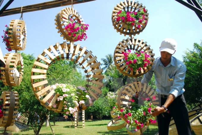 Các nghệ nhân làm các tiểu cảnh để sử dụng cho đường hoa Nguyễn Huệ. (Ảnh: Mạnh Linh/TTXVN)