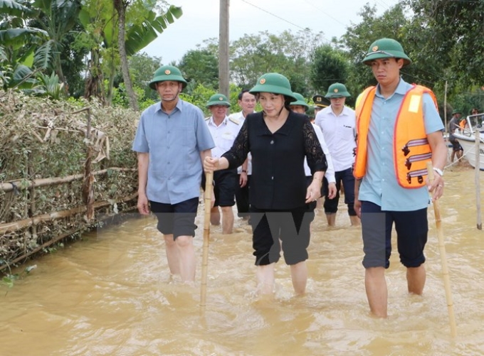 Chủ tịch Quốc hội Nguyễn Thị Kim Ngân đi thị sát tại xã Đức Hưng, huyện Vũ Quang vẫn đang ngập trong lũ. (Ảnh: TTXVN)