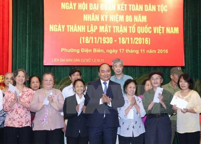 Thủ tướng Nguyễn Xuân Phúc tặng quà cho các hộ nghèo, hộ có hoàn cảnh đặc biệt khó khăn. (Ảnh: TTXVN)