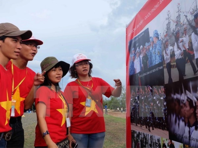 Sinh viên xem ảnh tại triển lãm ảnh "Tự hào biển đảo Việt Nam". (Ảnh: TTXVN