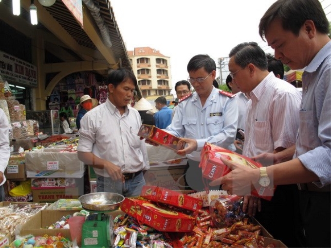 Đoàn Thanh tra Bộ Y tế và thanh tra liên ngành Thành phố Hồ Chí Minh kiểm tra bánh mứt Tết tại chợ Bình Tây. (Ảnh: TTXVN)