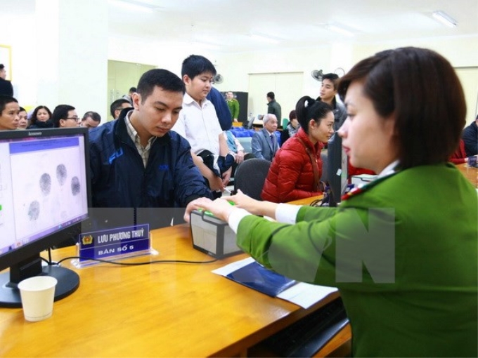 Cán bộ, chiến sỹ công an lấy làm thủ tục lấy dấu vân tay công dân đến đăng ký cấp thẻ căn cước công dân. (Ảnh: Doãn Tấn/TTXVN)