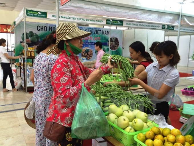 Người tiêu dùng mua rau quả tại phiên chợ nông sản. (Ảnh: Thanh Tâm/Vietnam+)