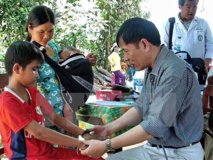 Khám và hội chẩn cho người dân mắc hội chứng viêm da dày sừng lòng bàn tay, bàn chân tại xã Ba Điền, huyện Ba Tơ hồi năm 2004. (Ảnh: TTXVN)