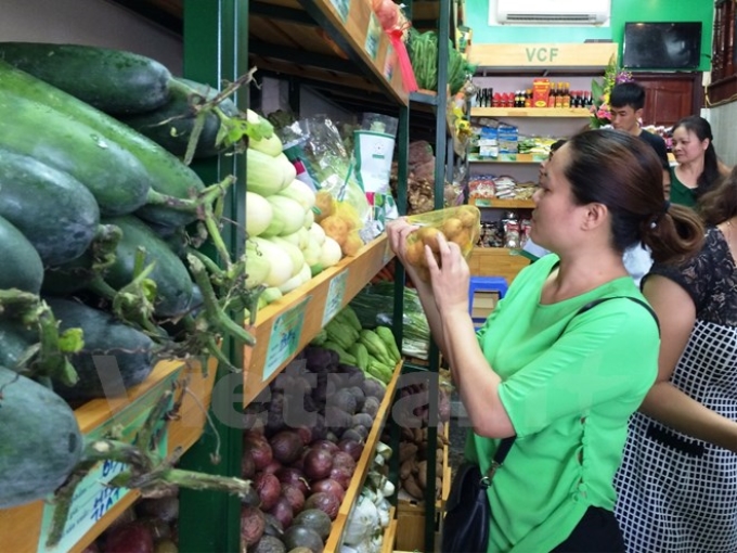 Người tiêu dùng mua hàng tại cửa hàng thực phẩm an toàn của Liên minh hợp tác xã Việt Nam. (Ảnh: Vietnam+)