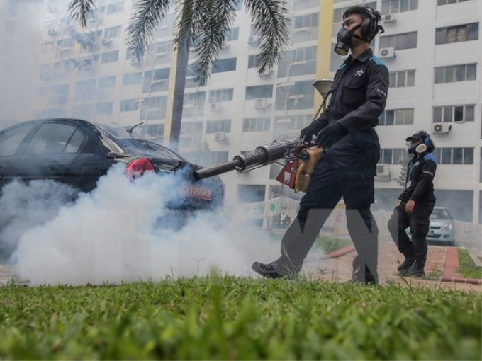 Phun thuốc diệt muỗi tại một khu dân cư ở quận Aljunied, Singapore. (Nguồn: EPA/TTXVN)