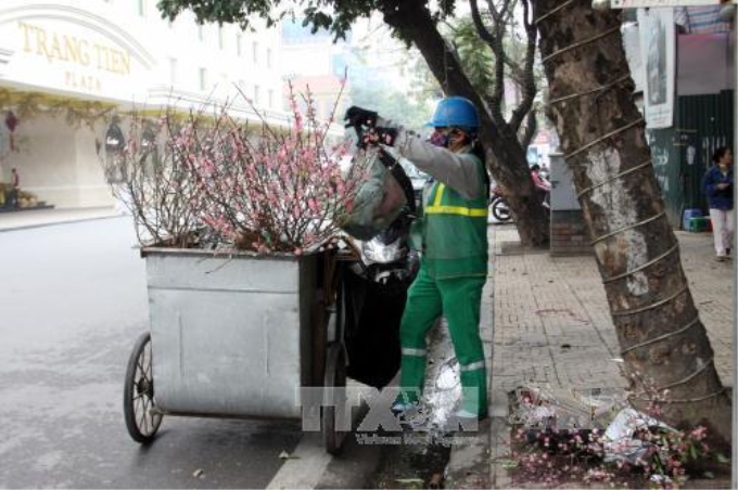 Công nhân Công ty TNHH Một thành viên Môi trường Đô thị Hà Nội quận Hoàn Kiếm thu dọn rác tại phố Hàng Bài. Ảnh: Tuấn Anh/TTXVN