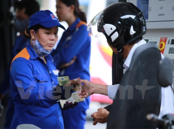 Nhân viên Petrolimex đang bán xăng cho khách hàng. (Ảnh: Vietnam+)