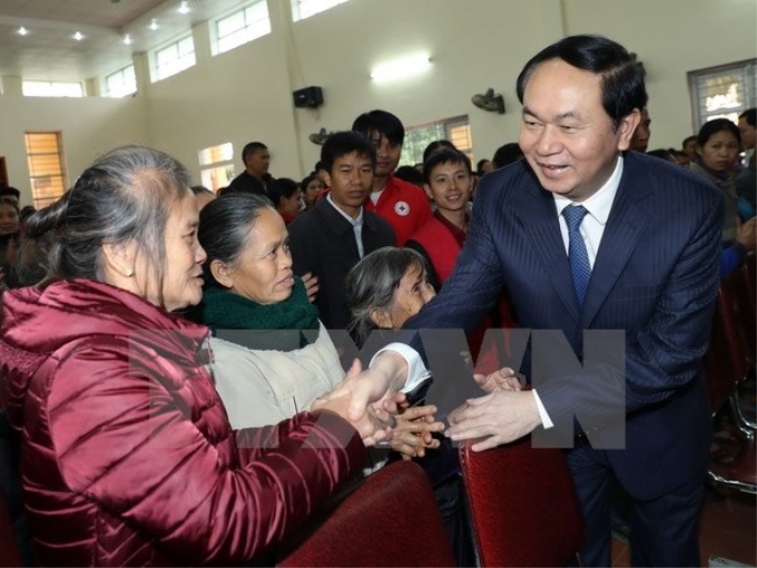 Chủ tịch nước Trần Đại Quang thăm hỏi, tặng quà và chúc Tết các gia đình chính sách của hai xã Nam Giang, Nam Lĩnh (huyện Nam Đàn). (Ảnh: TTXVN)