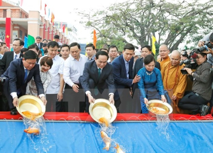 Chủ tịch nước Trần Đại Quang và Phu nhân cùng Bí thư Thành ủy TP. Hồ Chí Minh Đinh La Thăng và đông đảo bà con kiều bào thực hiện nghi lễ thả cá chép tại Bến cảng Nhà Rồng. (Ảnh: Nhan Sáng/TTXVN)