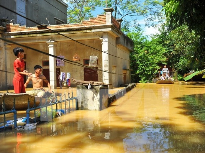 Nước ngập sâu nên người dân tại thôn Kiến Phong, xã Gia Tường, huyện Nho Quan, Ninh Bình phải di chuyển bằng thuyền. (Ảnh: TTXVN)