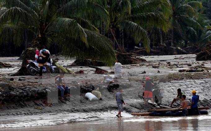 Người dân di chuyển bằng bè để qua sông sau bão Tembin tại tỉnh Lanao del Norte, Philippines ngày 23/12. (Nguồn: THX/TTXVN)