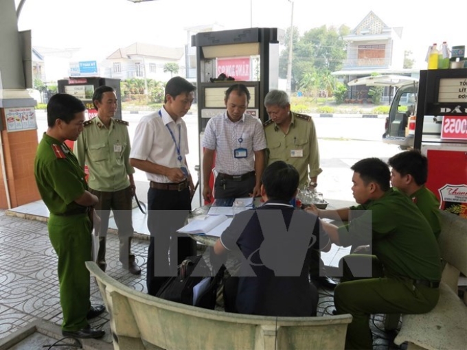 Lực lượng chức năng lập biên bản một cây xăng có gắn chíp gian lận. (Ảnh minh họa: TTXVN)