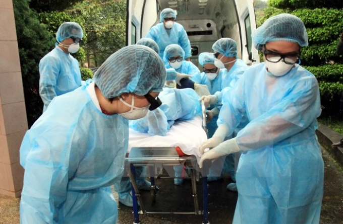 Cán bộ y tế chuyển bệnh nhân nghi mắc cúm A (H7N9) tới khu điều trị cách ly. (Ảnh: TTXVN)