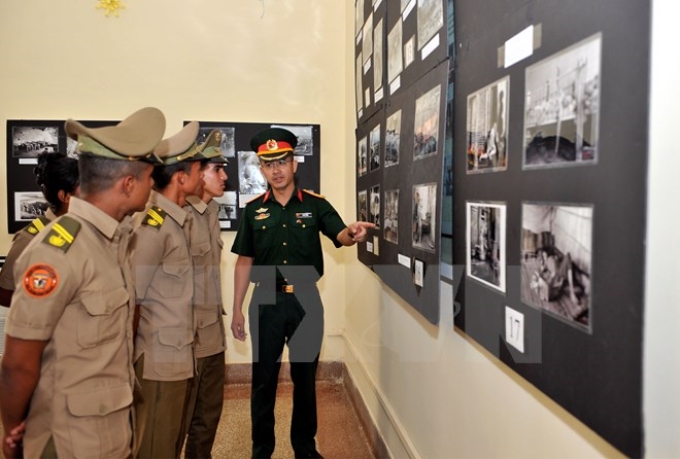 Tùy viên Quốc phòng Việt Nam tại Cuba Vũ Thế Trung giới thiệu các tác phẩm ảnh trưng bày tại triển lãm. (Ảnh: TTXVN)