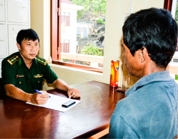 Trung tá Hoàng Trọng Hiệp lấy lời khai của đối tượng trong đường dây buôn bán lao động đi biển ở TP. Vũng Tàu. Ảnh: NVCC