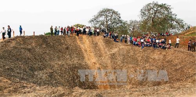 Khách tham quan hố độc phá trên đồi A1, Điện Biên Phủ. Ảnh: Thanh Tùng/TTXVN