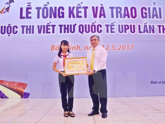 Thứ trưởng Bộ Thông tin và Truyền thông Nguyễn Minh Hồng trao giải nhất cuộc thi viết thư quốc tế UPU lần thứ 46 cho tác giả Nguyễn Đỗ Huyền Vi, học sinh lớp 8/9 Trường THCS Tây Sơn, Đà Nẵng. (Ảnh: TTXVN)