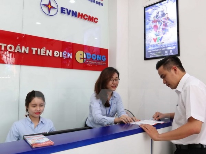 Đoàn Thanh niên EVN HCMC hướng dẫn khách hàng thanh toán tiền điện không dùng tiền mặt và các dịch vụ về điện. (Ảnh: TTXVN)