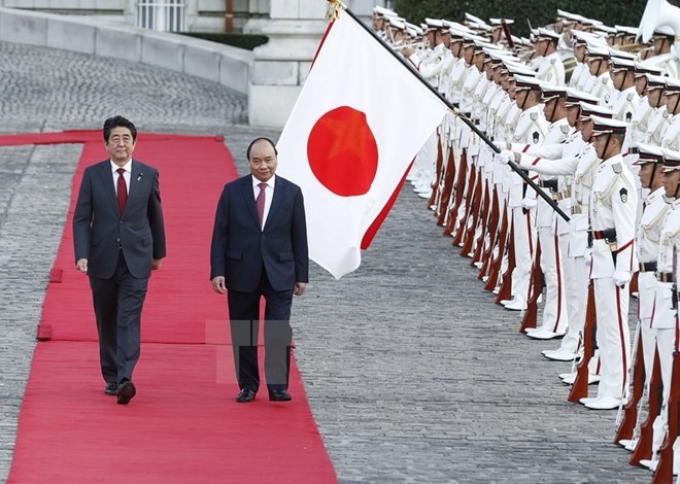 Thủ tướng Nhật Bản Shinzo Abe và Thủ tướng Nguyễn Xuân Phúc duyệt Đội danh dự tại Lễ đón chính thức. (Ảnh: TTXVN)