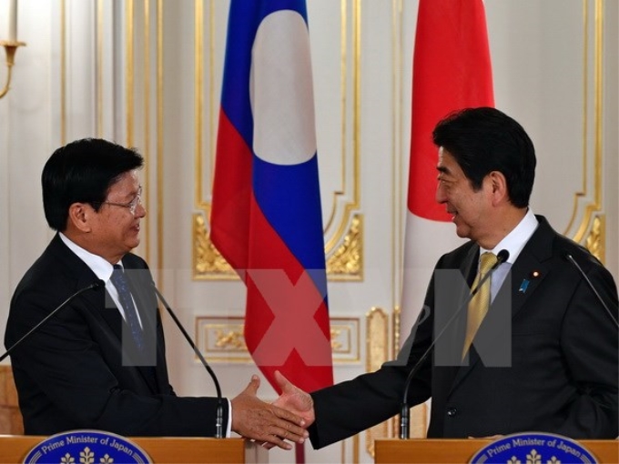 Thủ tướng Nhật Bản Shinzo Abe - bên phải và Thủ tướng Lào Thongloun Sisolith. (Ảnh: AFP/TTXVN)