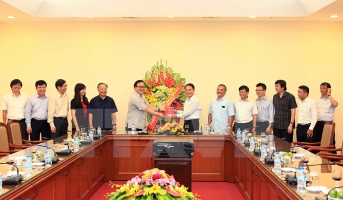 Ông Hoàng Trung Hải, Ủy viên Bộ Chính trị, Bí thư Thành ủy Thành phố Hà Nội đến tặng hoa chúc mừng cán bộ, phóng viên, biên tập viên của T​TXVN. (Ảnh: Quốc Khánh/TTXVN)
