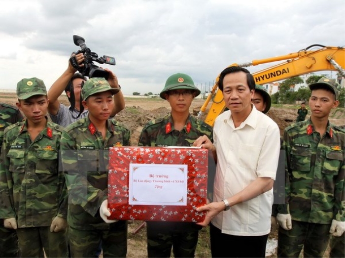 Bộ trưởng Đào Ngọc Dung tặng quà động viên lực lượng tìm kiếm hài cốt liệt sĩ tại sân bay Tân Sơn Nhất. (Ảnh: Thanh Vũ/TTXVN)