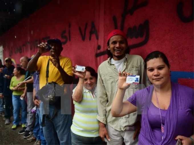 Người dân Venezuela xếp hàng chờ bỏ phiếu tại điểm bầu cử ở Caracas ngày 30/7. (Ảnh: AFP/TTXVN)