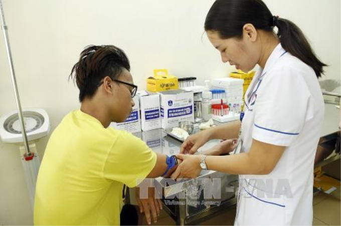 Nhân viên y tế xét nghiệm máu cho người bệnh mắc sốt xuất huyết tại Bệnh viện Đa khoa Đống Đa. Ảnh: Dương Ngọc/TTXVN